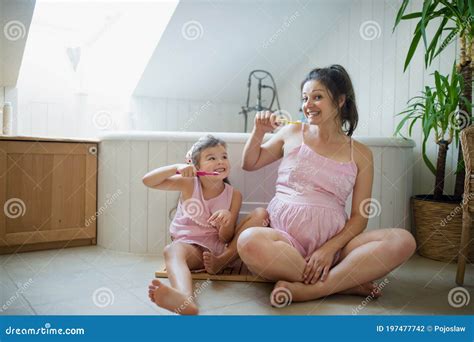 Portrait Of Pregnant Woman With Small Daughter Indoors In Bathroom At