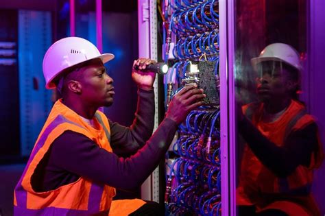 Premium Photo Concentrated Black Workman In Hardhat And Orange Vest