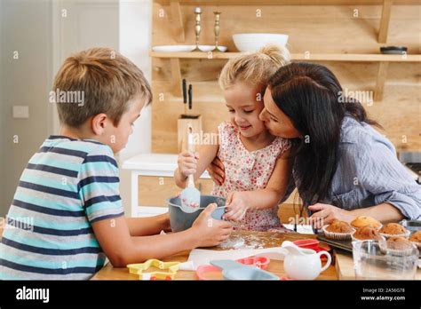 Mother and children baking cupcakes in kitchen Stock Photo - Alamy