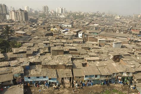 an aerial view of a slum city with people and shacks in the foreground