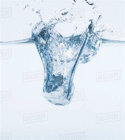 Ice Cube Splashing Into Water Studio Shot Stock Photo Dissolve