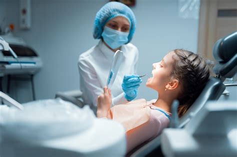 Uma Menina Paciente E Uma Dentista Est O Verificando Os Dentes No