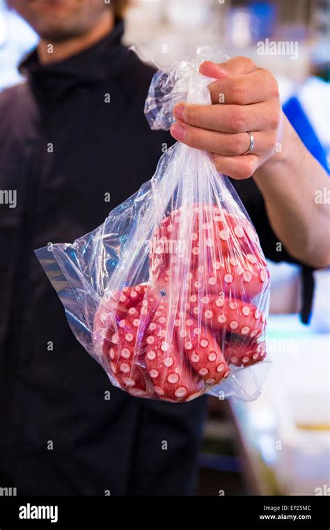 Hombre mano sosteniendo un pulpo en una bolsa de plástico en un mercado