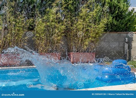 A Huge Splash Of Water Is Created By A Cannonball Dive Into A Swimming