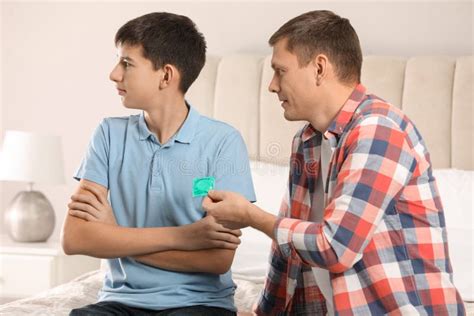 Father Giving Condom To His Teenage Son In Bedroom Sex Education