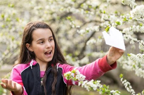 Niña feliz jugando con un avión de juguete en el jardín Foto Premium