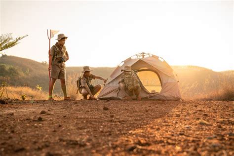 Teamwork Of Three Boy Scouts Attending Scout Camp Pitching Their Tents