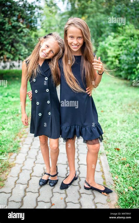 Two cute smiling little girls posing in school. Adorable little kids ...