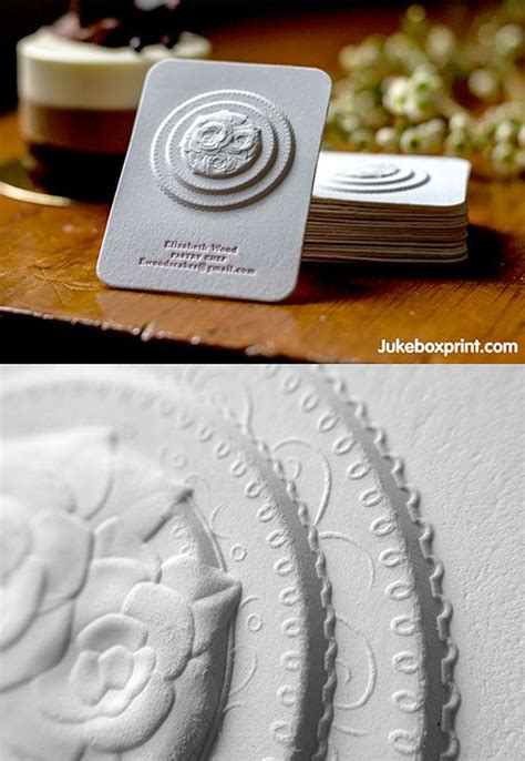 Some White Business Cards On Top Of A Wooden Table