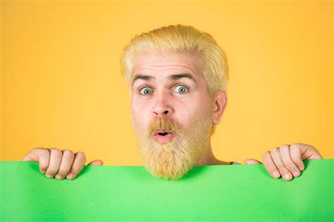 Premium Photo Man Holding A Blank Billboard Isolated On Yellow Background