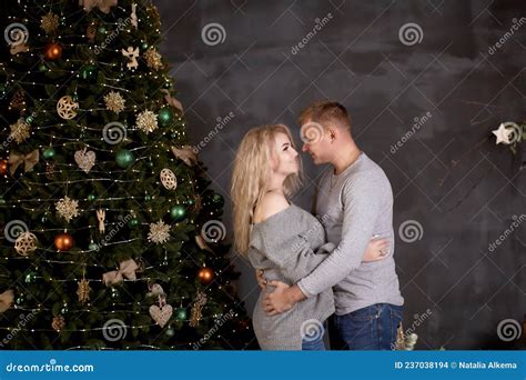 Enamored Couple Of Man And Blonde Woman In Aesthetic Cozy Home Interior With Festive Christmas