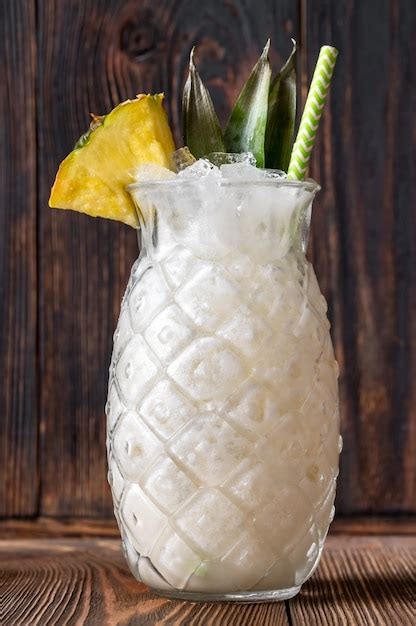 Premium Photo Glass Of Pina Colada Cocktail Garnished With Pineapple