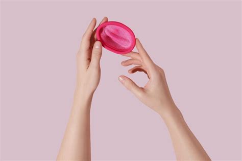 Manos Femeninas Con Disco Menstrual Reutilizable Sobre Fondo Rosa