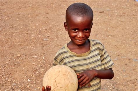 Premium Photo Portrait Of Smiling Boy With Soccer Ball Standing On Field