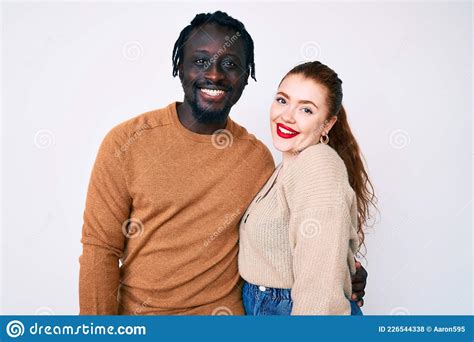 Interracial Couple Wearing Casual Clothes With A Happy And Cool Smile