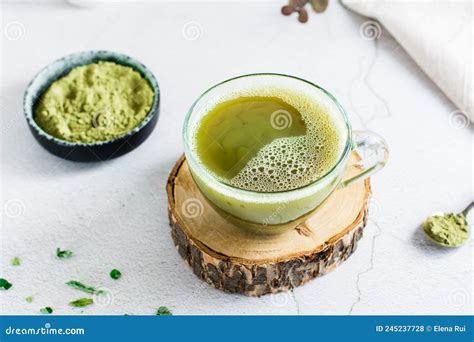 Organic Green Matcha Tea In A Cup On A Tree Trunk On The Table Close