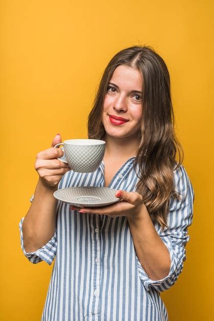 Retrato De Um Sorrindo Mulher Jovem Segurando Pires E Copo Em