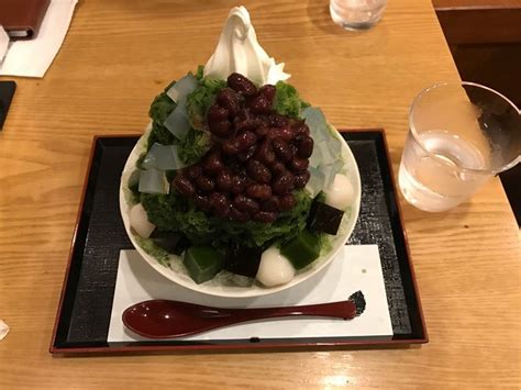 A Bowl Filled With Lettuce And Beans On Top Of A Wooden Table Next To A