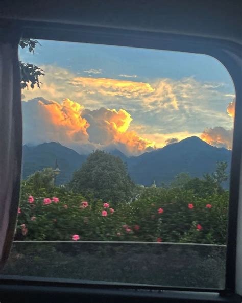 The Sun Is Setting Over Mountains As Seen From Inside A Train Window