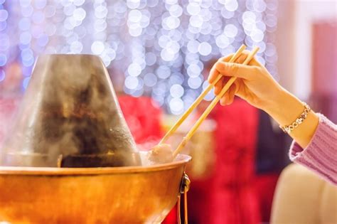 Premium Photo Hot Pot Hot Pot With A Hand With Chopsticks