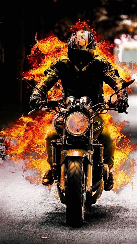 A Man Riding On The Back Of A Motorcycle Covered In Flames