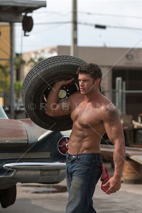 Shirtless Auto Mechanic At A Garage Carrying A Tire Gorgeous