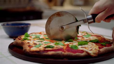 Cutting Pizza With a Pizza Cutter 18904274 Stock Video at Vecteezy