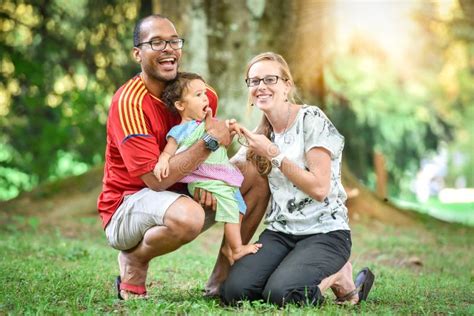 Den Lyckliga Mellan Skilda Raser Familjen Tycker Om En Dag I Parkera