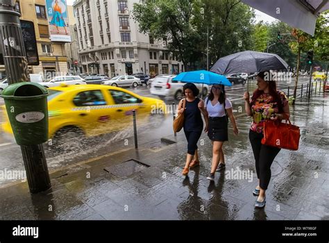 Bucharest, Romania - August 01, 2019: Women walking with umbrellas, in ...