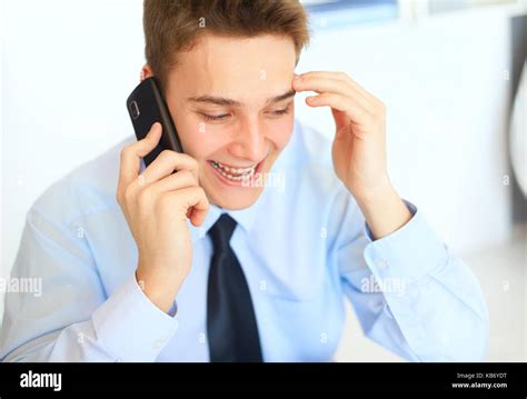 Retrato de joven empresario de risa hablando por teléfono celular en la