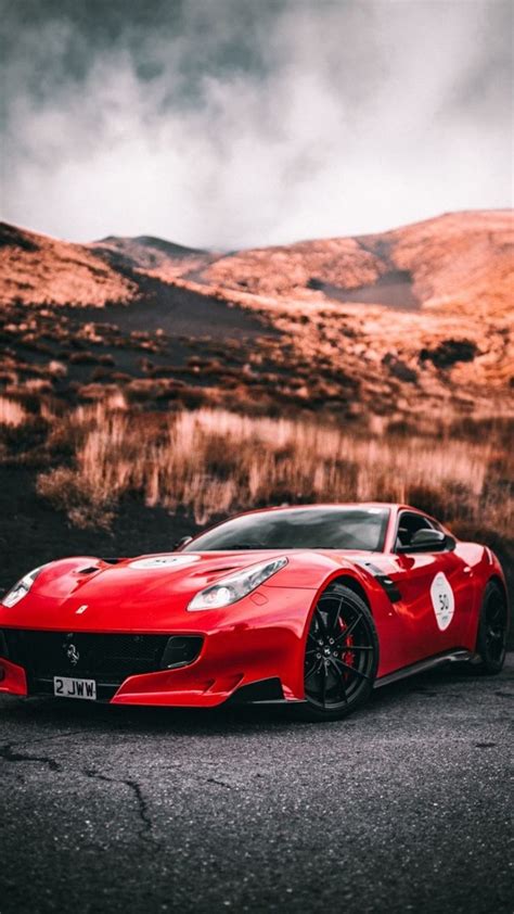 A Red Sports Car Parked In Front Of A Mountain