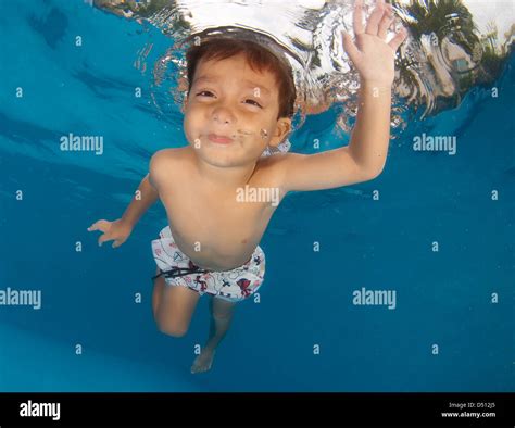 Little 3 Years Old Boy Playing On The Surface Of A Swimming Pool Stock