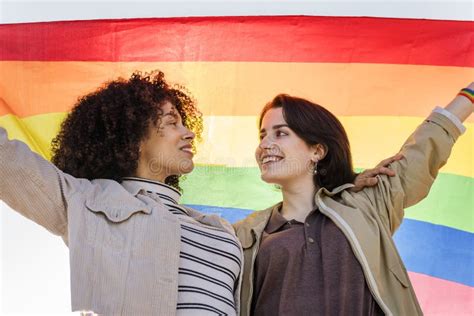 Lesbian Couple Embracing Wrapped In A Rainbow Flag Stock Image Image