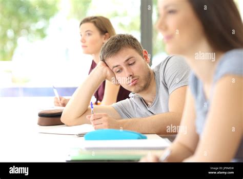 Bored Student Distracted During A Class At Classroom With Classmates In