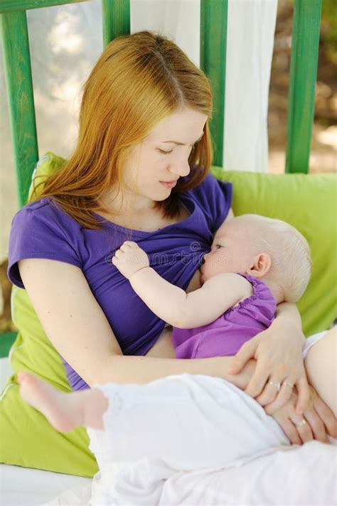 Giovane Madre Che Allatta Al Seno Un Bambino In Natura Fotografia Stock