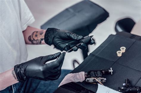 Preparando máquina de tinta mestre de tatuagem profissional definindo