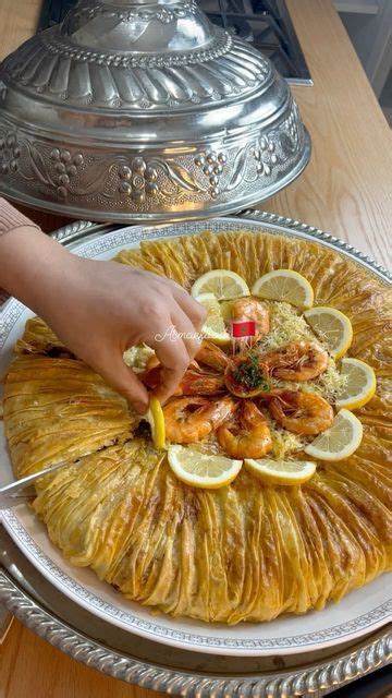 A Person Is Placing Lemons On Top Of A Large Platter Filled With Food