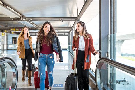 Glad Friends With Suitcase Walking Fast By Walkway In Airport By