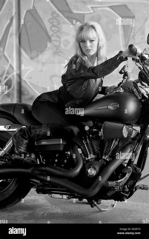 Beautiful Blonde Girl In Black With A Harley Davidson Motorcycle Stock