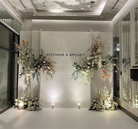 Two Tall Vases Filled With Flowers Sitting On Top Of A White Floor Next