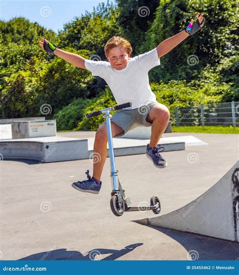 O Menino Salta Seu Trotinette Foto De Stock Imagem De Sorriso