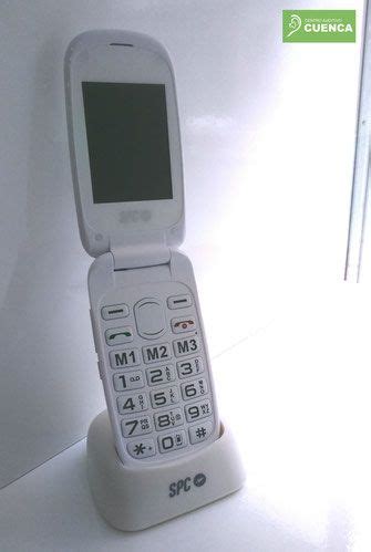 An Old Cell Phone Sitting On Top Of A White Stand With The Screen