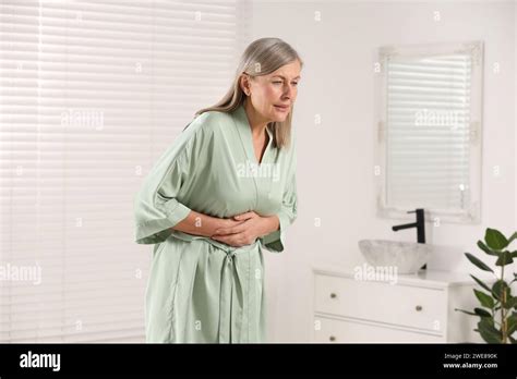 Menopause Woman Suffering From Digestive Problems In Bathroom Stock