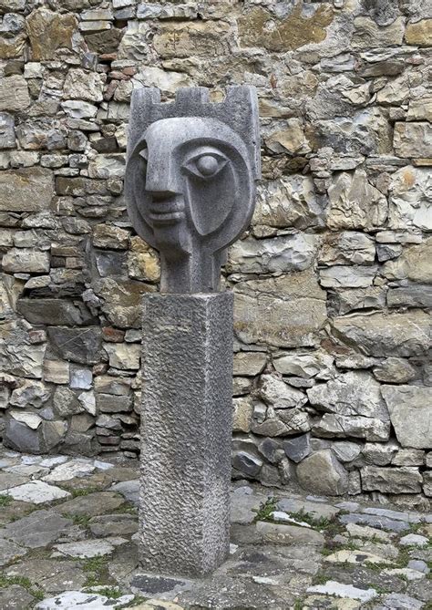 Stone Statue With Stylized Face In A Small Stone Courtyard In