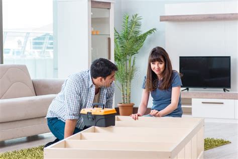 Los Muebles De Junta De La Familia Joven En La Nueva Casa Foto De