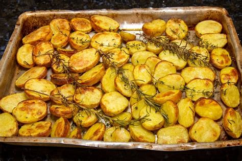 Una Bandeja De Patatas Asadas Al Horno Con Romero Encima Foto Premium