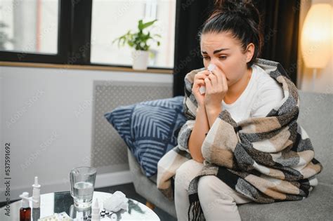 Ill Young Woman Sit On Sofa Covered With Blanket Freezing Blowing Her