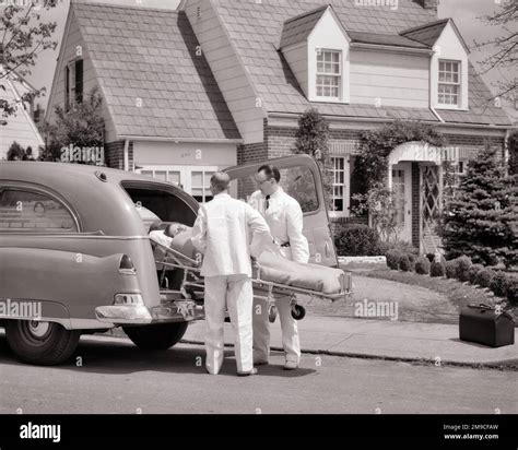 1950s Two Ambulance Attendants Emts With Woman On Stretcher In Front Of