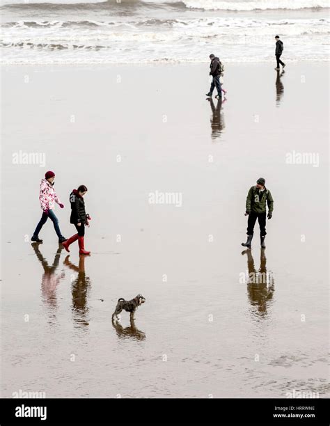 Menschen Spiegeln Sich Im Nassen Sand Am Strand Von Scarborough Fotos