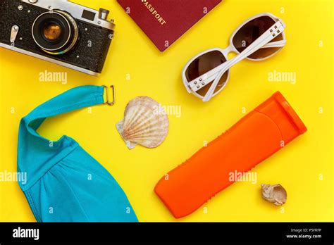Flat Lay With Bikini Plane Vintage Camera Passport Sunscreen Sunglasses And Shell On Yellow